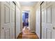 Hallway with linen closets leads to a bathroom, featuring white doors and wood-style floors at 1071 Nordyke Ave, Henderson, NV 89015