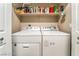 Well-equipped laundry room with washer, dryer, and overhead shelving for storage at 1071 Nordyke Ave, Henderson, NV 89015