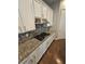 This kitchen features a granite countertop, a mosaic backsplash, and white cabinets at 10732 Irving Park Ave, Las Vegas, NV 89166