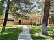 The community clubhouse boasts a walkway entrance, green lawn, and shade trees at 1150 N Buffalo Dr # 1005, Las Vegas, NV 89128