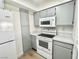 Kitchen with white appliances, gray cabinets, and a pantry for extra storage at 1150 N Buffalo Dr # 1005, Las Vegas, NV 89128