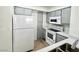 Galley kitchen features grey cabinets, white appliances and light countertops at 1150 N Buffalo Dr # 1005, Las Vegas, NV 89128