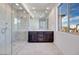Modern bathroom with a glass shower, double vanity, and large window with neighborhood view at 1320 Crimson Sunbird Ave, North Las Vegas, NV 89084