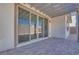 Covered patio with a brick floor and glass sliding doors leading inside the house at 1320 Crimson Sunbird Ave, North Las Vegas, NV 89084