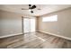 Spacious bedroom featuring wood floors, a ceiling fan, and sliding glass doors for natural light at 2110 Bavington Dr # C, Las Vegas, NV 89108