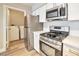 Well-equipped kitchen with stainless steel appliances, white countertops and cabinets, and a view of the laundry area at 2110 Bavington Dr # C, Las Vegas, NV 89108
