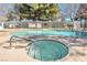 Community swimming pool with a hot tub and lounge chairs under the trees on a clear sunny day at 2110 Bavington Dr # C, Las Vegas, NV 89108