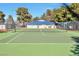 Outdoor tennis court with well-maintained green surface, surrounded by trees and fencing under a clear blue sky at 2110 Bavington Dr # C, Las Vegas, NV 89108