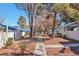 Community walkway surrounded by mature trees and landscaping, leading to the attached houses on a sunny day at 2110 Bavington Dr # C, Las Vegas, NV 89108