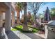 Lush backyard with artificial turf, mature landscaping, and outdoor kitchen at 2204 Ambermill Ct, Henderson, NV 89052