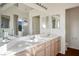 Modern bathroom featuring dual sinks with a large mirror and a separate door leading to the shower room at 2204 Ambermill Ct, Henderson, NV 89052