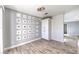 Dining area features wood-look flooring, a modern chandelier, and built-in storage, perfect for entertaining at 2340 Hunt Club St, Las Vegas, NV 89128