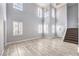 Spacious living area boasts wood-look flooring, large windows with shutters, and a staircase to the upper level at 2340 Hunt Club St, Las Vegas, NV 89128