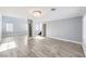 Bright living room with wood-look tile flooring, modern lighting fixture, and white accents at 2340 Hunt Club St, Las Vegas, NV 89128