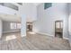Open-concept layout featuring wood-look flooring, soaring ceilings, and seamless flow to the kitchen area at 2340 Hunt Club St, Las Vegas, NV 89128
