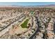 A high-angle image captures a golf course weaving through a desert neighborhood under a clear, sunny sky at 2493 Ram Crossing Way, Henderson, NV 89074