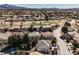 A high angle captures houses next to the fairways of a golf course, surrounded by desert vegetation at 2493 Ram Crossing Way, Henderson, NV 89074