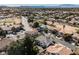 Expansive aerial view of a desert neighborhood with golf course and mountain views on a sunny day at 2493 Ram Crossing Way, Henderson, NV 89074