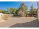 Spacious backyard showcasing neutral tones, satellite dish, and desert landscaping at 2493 Ram Crossing Way, Henderson, NV 89074