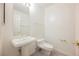Powder room featuring a pedestal sink, toilet, and gold fixtures at 2493 Ram Crossing Way, Henderson, NV 89074