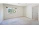 Bright bedroom featuring a window, neutral carpet, and a door leading to additional spaces at 2493 Ram Crossing Way, Henderson, NV 89074