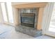Close-up of a fireplace with a wooden mantel, marble hearth, and access to the backyard at 2493 Ram Crossing Way, Henderson, NV 89074