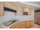 Traditional kitchen with wood cabinets, stove top, and black appliances at 2493 Ram Crossing Way, Henderson, NV 89074