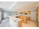 Kitchen with wooden cabinetry, light countertops, island with sink, and tile floor at 2493 Ram Crossing Way, Henderson, NV 89074