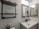Bathroom showcasing vanity with a gray cabinet, modern fixtures, industrial-style shelving, and dual mirrors at 3213 Oyster Bay St, Las Vegas, NV 89117