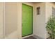 Close up shot of a green front door, exterior light fixture and accent rug at 3213 Oyster Bay St, Las Vegas, NV 89117