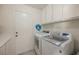 Convenient laundry room equipped with modern washer and dryer units, ample cabinet storage, and a utility sink at 3213 Oyster Bay St, Las Vegas, NV 89117