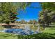 Scenic pond with a rock waterfall feature surrounded by lush green landscaping and mature trees at 3213 Oyster Bay St, Las Vegas, NV 89117