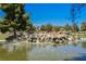 Charming community pond featuring a decorative rock waterfall and ample greenery around its banks at 3213 Oyster Bay St, Las Vegas, NV 89117