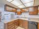 A kitchen with brown cabinets, laminate countertops, with essential appliances at 3251 Southridge Ave, Las Vegas, NV 89121