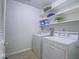 A practical laundry room with a washer, dryer, and storage shelves for organization at 3251 Southridge Ave, Las Vegas, NV 89121