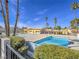 Community pool with a sunning deck and mature landscaping and palm trees surrounding the area at 3251 Southridge Ave, Las Vegas, NV 89121
