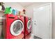 Functional laundry room featuring a bright red washer and dryer set and white door at 3901 W Red Coach Ave, North Las Vegas, NV 89031