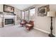 Cozy living room featuring a fireplace, carpet, and large window views at 3901 W Red Coach Ave, North Las Vegas, NV 89031