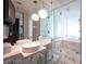 Modern bathroom with marble countertops, dual sinks, large mirror, and a glass-enclosed shower and tub combo at 4381 W Flamingo Rd # 3303, Las Vegas, NV 89103