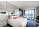 Modern bedroom with a king-size bed, sitting area, and city views through large windows at 4381 W Flamingo Rd # 3303, Las Vegas, NV 89103