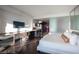 Spacious bedroom featuring a white bed, dark floors, a workspace, and a partial kitchen view at 4381 W Flamingo Rd # 3303, Las Vegas, NV 89103