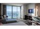 Well-lit living room featuring mountain views, a comfortable gray sofa, and wall-mounted television at 4381 W Flamingo Rd # 3303, Las Vegas, NV 89103