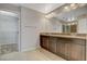 Bathroom featuring double vanity with dark wood cabinets and a walk-in closet at 5309 Tartan Hill Ave, Las Vegas, NV 89141