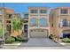 Three-story townhome featuring a two car garage, small front yard, and second story balcony at 5309 Tartan Hill Ave, Las Vegas, NV 89141