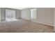 Spacious living room with plush carpeting and a sliding glass door to the backyard at 5309 Tartan Hill Ave, Las Vegas, NV 89141