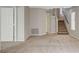 Another view of the carpeted living area with stairs and multiple doors at 5309 Tartan Hill Ave, Las Vegas, NV 89141