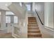 Carpeted staircase featuring sleek black handrails and landing with bright, natural light at 5309 Tartan Hill Ave, Las Vegas, NV 89141