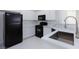 Bright kitchen featuring black appliances, white cabinetry and marble countertops at 5855 Valley Dr # 2018, North Las Vegas, NV 89031