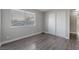Bright bedroom with wood-look floors, horizontal window blinds, and closet with sliding doors at 608 Cragin Park Dr, Las Vegas, NV 89107