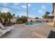 Backyard pool and patio with white lounge chairs and lush landscaping is perfect for relaxation at 608 Cragin Park Dr, Las Vegas, NV 89107
